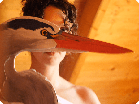 Claire derrière une tête de héron en bois peint